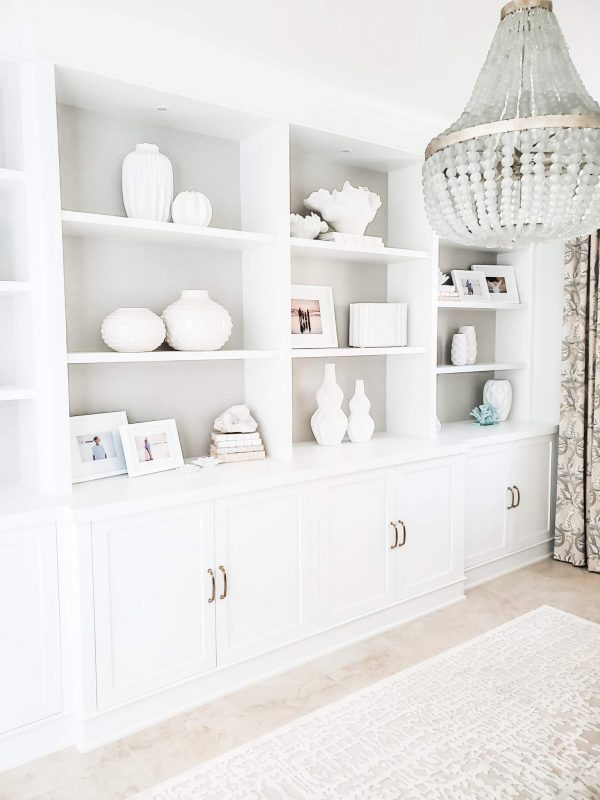 Room design inspiration. Custom white bookcase lined with crystal beaded wallpaper. The frosted crystal beads on the chandelier add a subtle glam to this home office. By Sally Soricelli. Nestorations.